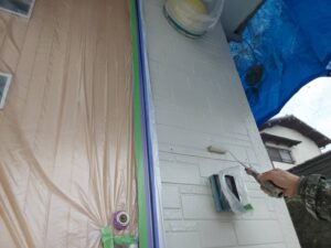 水戸市D様邸の外壁塗装で中塗り作業をしている様子