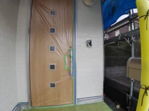 水戸市D様邸の外壁塗装で中塗り後の状態を確認している様子